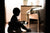 Child sitting on a potty in a dimly lit bedroom, experiencing toilet training regression, with Oopsie Heroes providing gentle support.